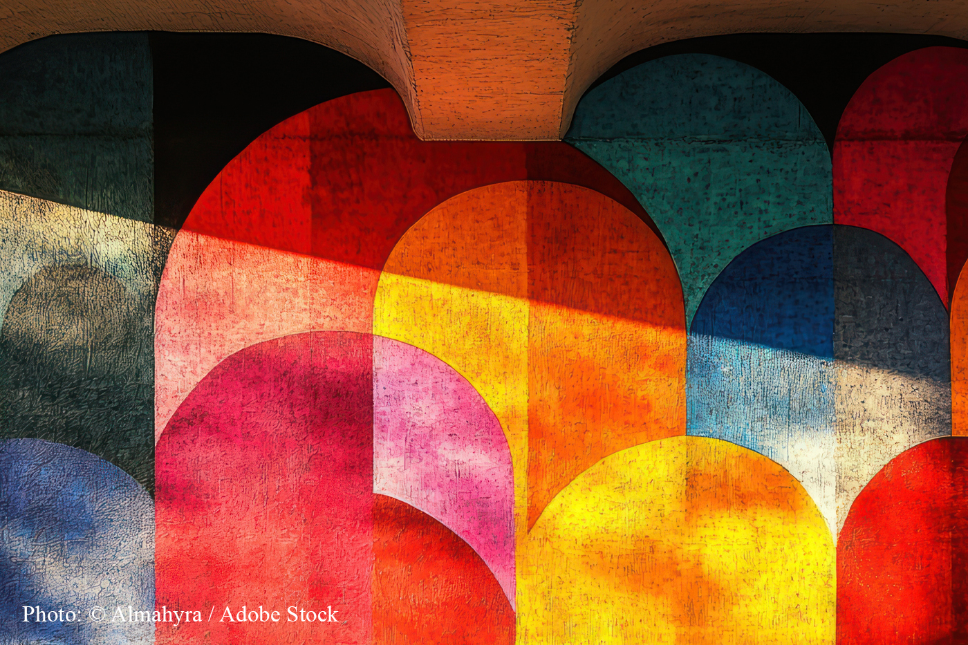 Painted arches in overlapping red, orange and blue, lit by a diagonal band of light